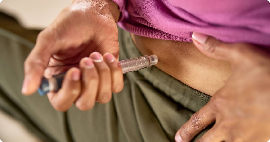 Close up of a person using an injection pen