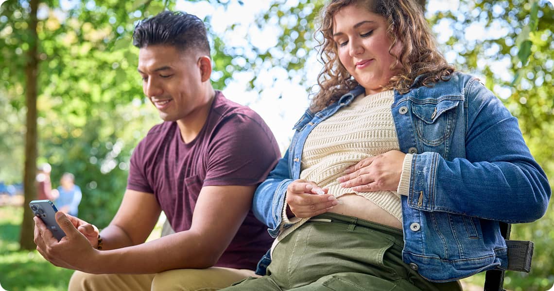 Person using an injection pen on an outside bench