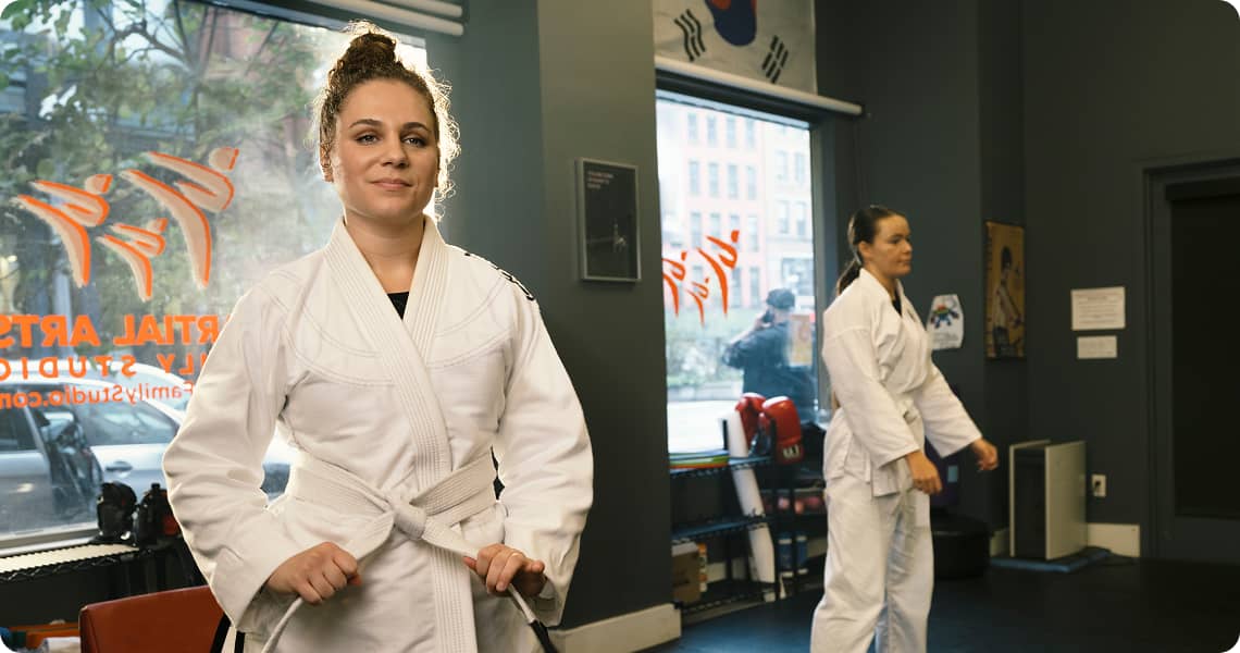 Two people wearing a Gi inside a martial arts studio