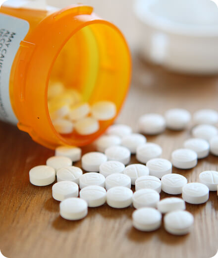 Tablets spilling out of a pill bottle on a table