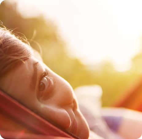 Person grinning at the camera while lying in a hammock