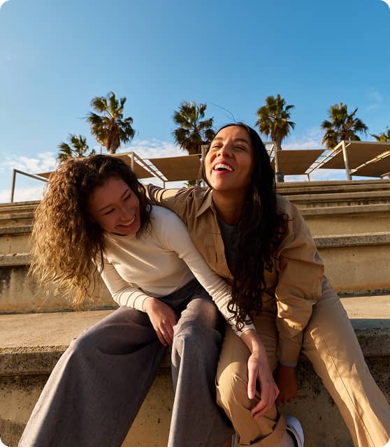 Two people sitting outside together smiling