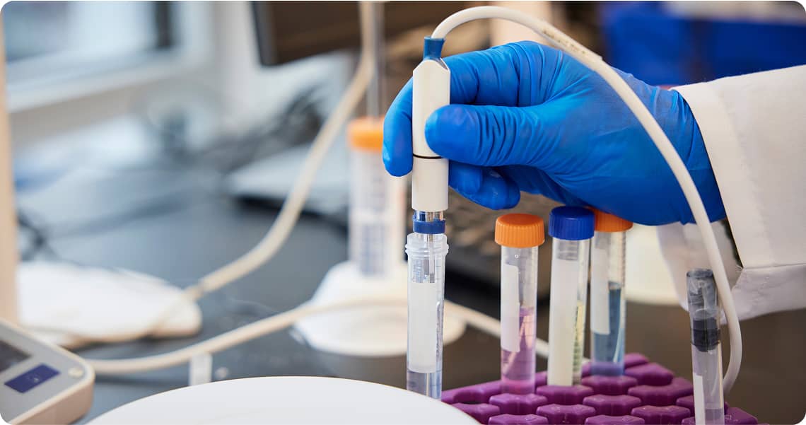 Close-up of a syringe interacting with a vial in a lab