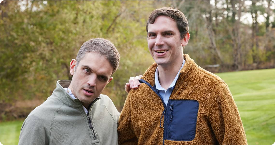 Two people standing together with an arm around each other looking into the camera